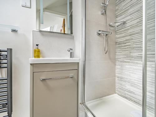 a bathroom with a shower and a sink at Rowan - Woodland Cottages in Bowness-on-Windermere