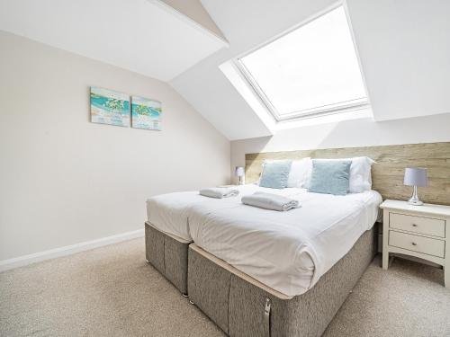 een slaapkamer met een groot bed en een raam bij Beech - Woodland Cottages in Bowness-on-Windermere