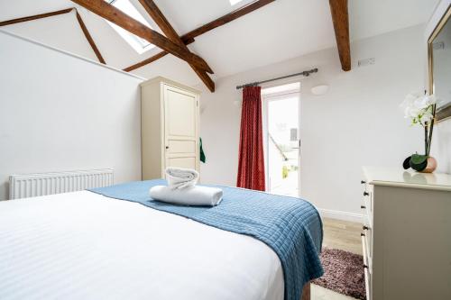 una camera da letto con un letto bianco e una finestra di Acorn a Windermere
