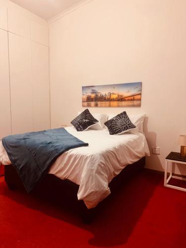 a bedroom with a bed with a painting on the wall at StoneWall Villa in Mbabane