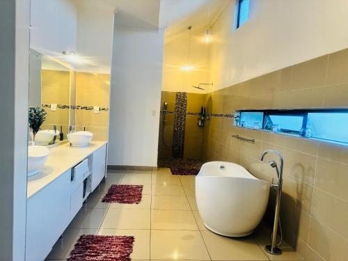 ein Badezimmer mit zwei Waschbecken und einer großen Badewanne in der Unterkunft StoneWall Villa in Mbabane