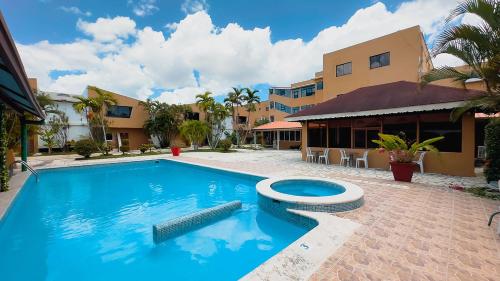 a swimming pool in front of a building at Hotel Tropicana Santo Domingo in La Viva