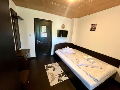 a small room with a bed with towels on it at Casa Munții Rodnei in Borşa