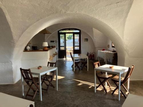 a dining room with tables and chairs and an archway at Masseria Purgatorio in Fasano