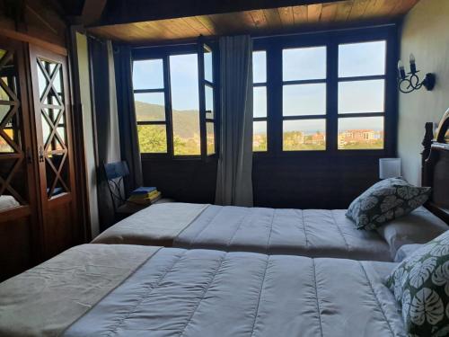 um quarto com uma cama grande e uma janela em Complejo turístico Las Mimosas del Nalon, LOS NOVALES em San Juan de la Arena