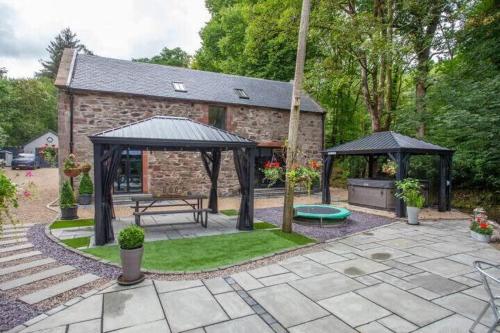 a backyard with a picnic table and a gazebo at The Ultimate Luss Retreat in Luss