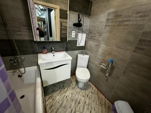 uma casa de banho com um WC, um lavatório e um espelho. em Apartment on Vatutina em Vinnytsya