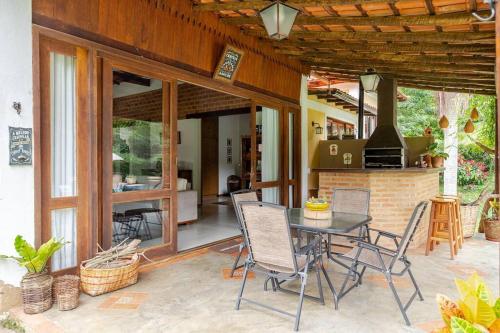 un patio con mesa, sillas y chimenea en Casa de campo Secretário/ Pedro do Rio RJ, en Petrópolis