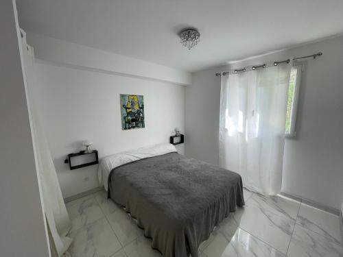 une chambre blanche avec un lit et une fenêtre dans l'établissement Rez de villa golfe de lava, à Appietto