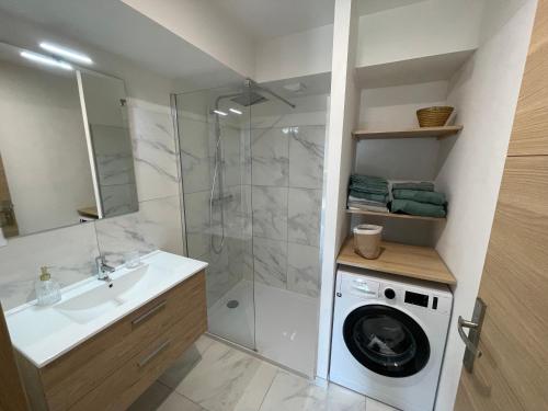 une salle de bain avec une machine à laver et un lave-linge dans l'établissement Rez de villa golfe de lava, à Appietto