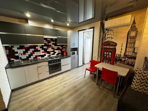 uma grande cozinha com uma mesa e cadeiras vermelhas em Апартаменти Східна Перлина em Vinnytsya