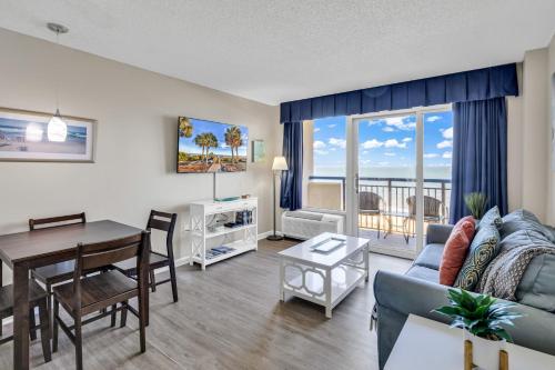 a living room with a couch and a table and a dining room at Boardwalk Resort 537 in Myrtle Beach
