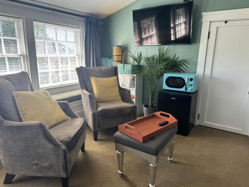 a living room with two chairs and a tv at Bayberry Inn B&B and Oregon Wellness Retreat in Ashland