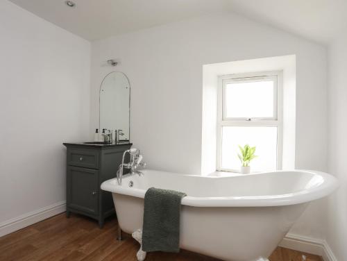 baño con bañera blanca y ventana en Maes Y Ddol en Pwllheli