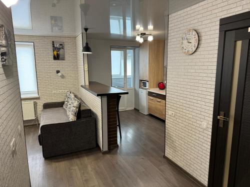 een woonkamer met een tafel en een bank en een keuken bij Затишна квартира для Вашої родини in Vinnytsya