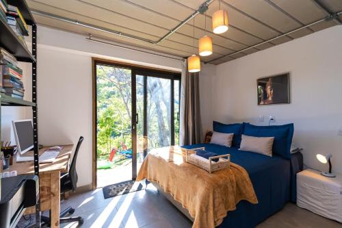 a bedroom with a blue bed and a desk at Santa Serra Itaipava in Itaipava