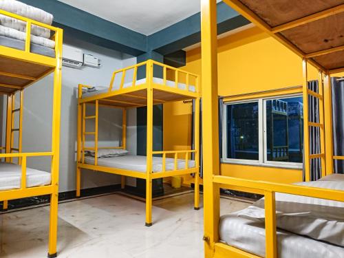 Pokój z żółtymi łóżkami piętrowymi w obiekcie Hostel Osara w mieście Bodh Gaja