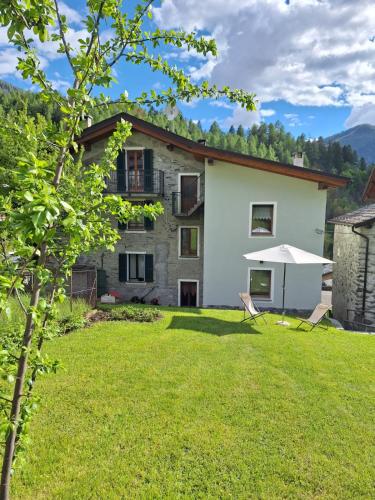 a house with a lawn in front of it at Appartamento Ca' Battaglia in Chiesa in Valmalenco