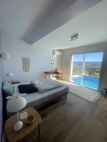 un salon avec un lit et une grande fenêtre dans l'établissement Amazing view seaside villa, à La Seyne-sur-Mer