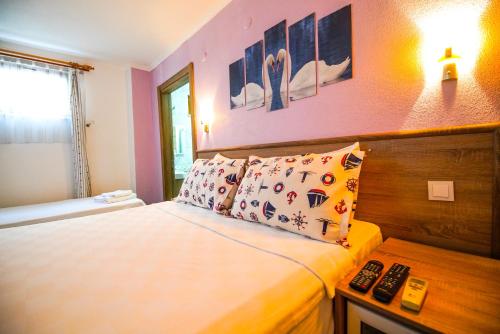 ボズジャ島にあるBozcaada Hotel Vitisのベッドルーム(ベッド1台、リモコン付)