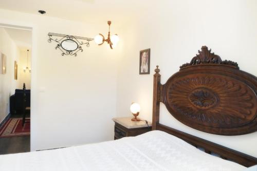 een slaapkamer met een bed met een houten hoofdeinde bij Vila da Paixão in Pedraça