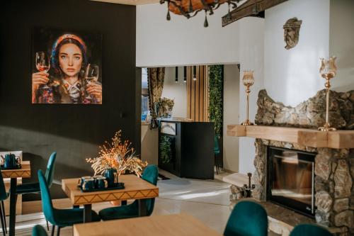 a dining room with a fireplace and a painting of a woman at Gordonówka Grand- blisko basenów termalnych Rezerwuj już dziś- nie przegap okazji! in Szaflary