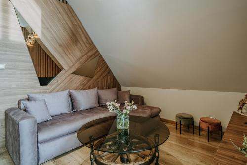 a living room with a couch and a glass table at Gordonówka Grand- blisko basenów termalnych Rezerwuj już dziś- nie przegap okazji! in Szaflary