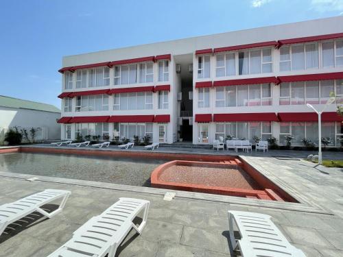 a building with a pool and lounge chairs in front of it at La Maisson Blanche Baku in Baku