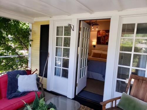 a porch with a red couch and a glass table at Bayberry Inn B&B and Oregon Wellness Retreat in Ashland