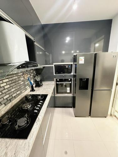 a kitchen with stainless steel appliances and a stove at Departamento Deluxe in Piura