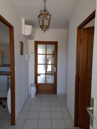 un couloir avec une porte et un lustre dans l'établissement maison marssac, à Marssac-sur-Tarn