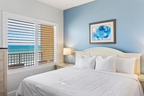 a bedroom with a white bed and a window at Royal Floridian Resort South by Spinnaker in Ormond Beach