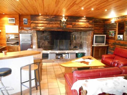 een woonkamer met een rode bank en een keuken bij Maison au Giraldès Le Claux Puy Mary Volcan chalet in Le Claux