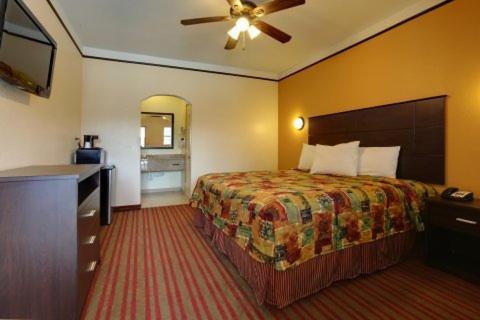 a hotel room with a bed and a television at Guest Inn San Benito/Harlingen in San Benito