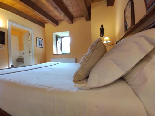 a bedroom with a large white bed with pillows at Hotel Boutique Villa de Palacios - Palacio de Aras in San Miguel de Aras