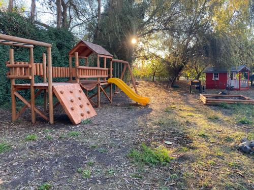 um parque com um parque infantil com um escorrega e um escorrega em Casa en entorno natural em Curicó