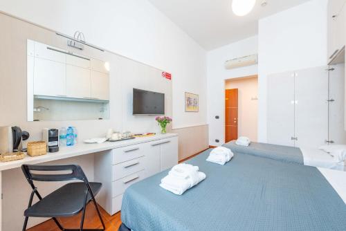 una camera con due letti e una sedia e una cucina di ANDENIS TIBER HOUSE a Roma