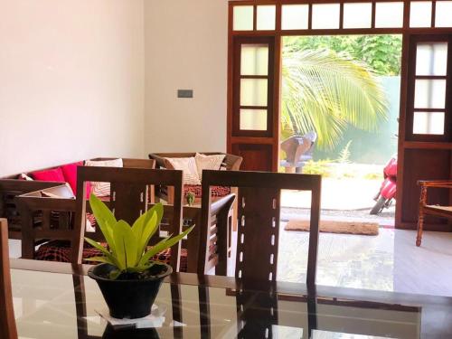 a dining room with a glass table with a plant on it at Villa Seagull in Hikkaduwa