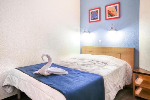 a room with a bed with a swan on a table at Résidence Le Beach - maeva Home - 2 Pièces 5 Personnes Confort 67 in Trouville-sur-Mer