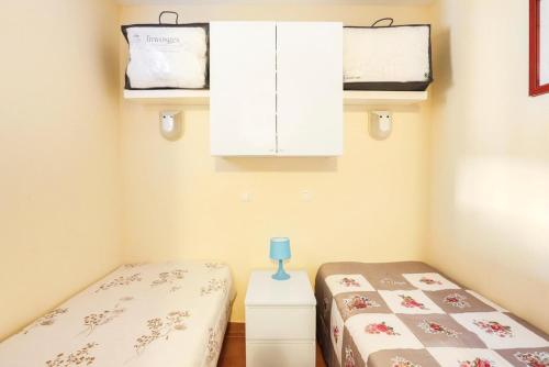 - 2 lits jumeaux dans une chambre avec des armoires dans l'établissement Village Pont Royal en Provence - maeva Home - 2 Pièces 4 Personnes Sélection MAE-2180, à Mallemort