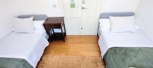 two beds sitting next to each other in a room at Donna Nega Alojamento Local in Caminha