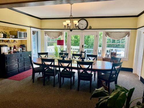 uma sala de jantar com mesa e cadeiras e um relógio em Bayberry Inn B&B and Oregon Wellness Retreat em Ashland