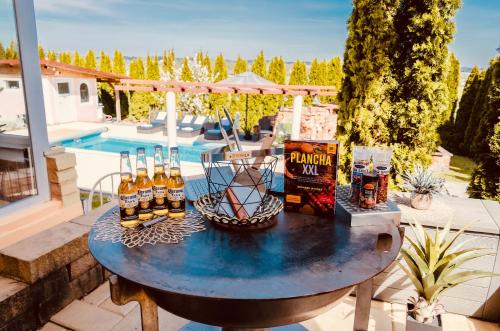 uma mesa com garrafas de cerveja sentadas num pátio em 5 Sterne Centurion Ferienhaus Villa 2 Pools 86 Zoll TV em Aldersbach