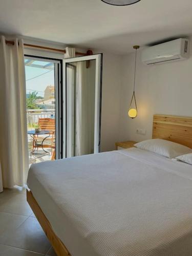 ein Schlafzimmer mit einem weißen Bett und einem Balkon in der Unterkunft Sihena in Skiathos-Stadt