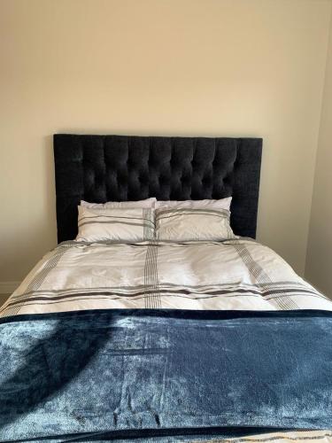 a large bed with a black headboard in a bedroom at Guthulele Living in Ballito