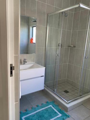 a bathroom with a shower with a sink and a tub at Guthulele Living in Ballito
