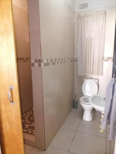 a bathroom with a toilet and a sink at Hhusha Hhusha in Malelane