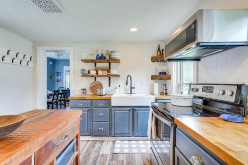 a large kitchen with blue cabinets and a sink at Lovely Ludlow Farmhouse about 1 Mi to Town and Slopes! in Ludlow