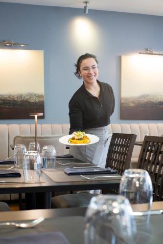 a woman holding a plate of food in a restaurant at Lisboa Central Park Hotel Suites & Studios in Lisbon