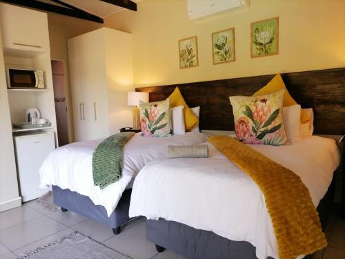 1 dormitorio con 2 camas con sábanas blancas en Hhusha Hhusha, en Malelane